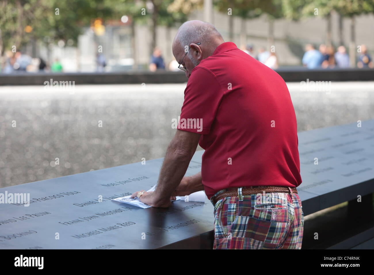 A visitor creates a rubbing of one of the names at the National September 11 Memorial in New York City. Stock Photo