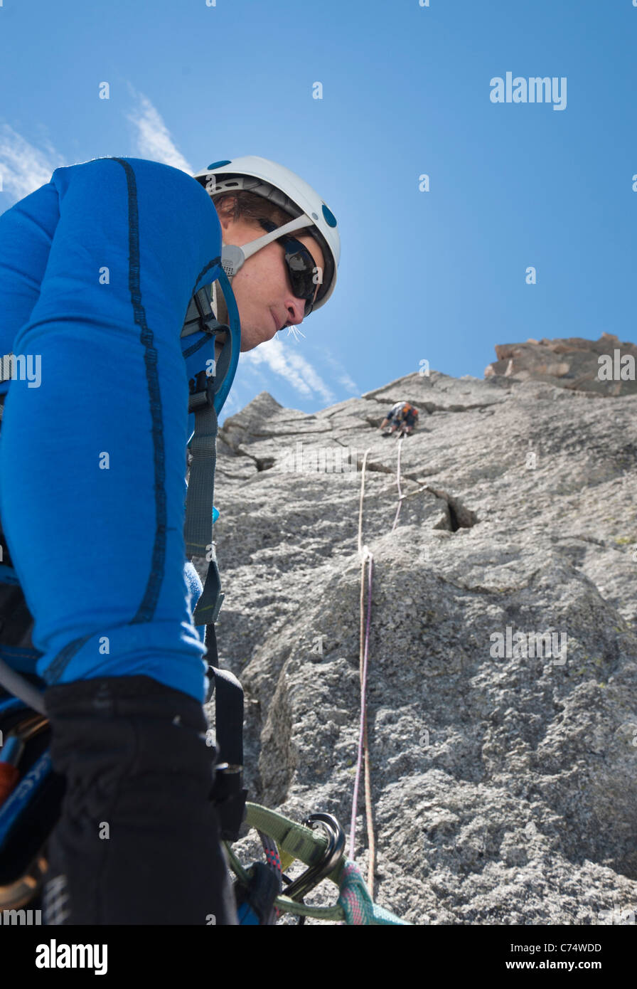 A belayer belaying his climbing partner on the granite of Pyramide du