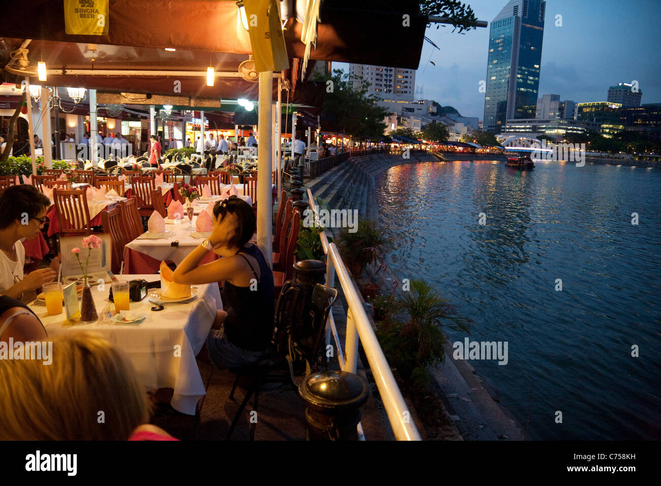 People eating at restaurants on Boat Quay by the Singapore River