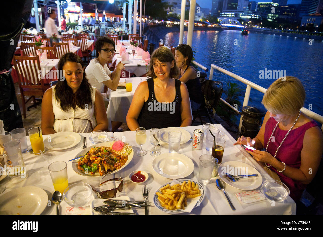 People eating at restaurants on Boat Quay by the Singapore River