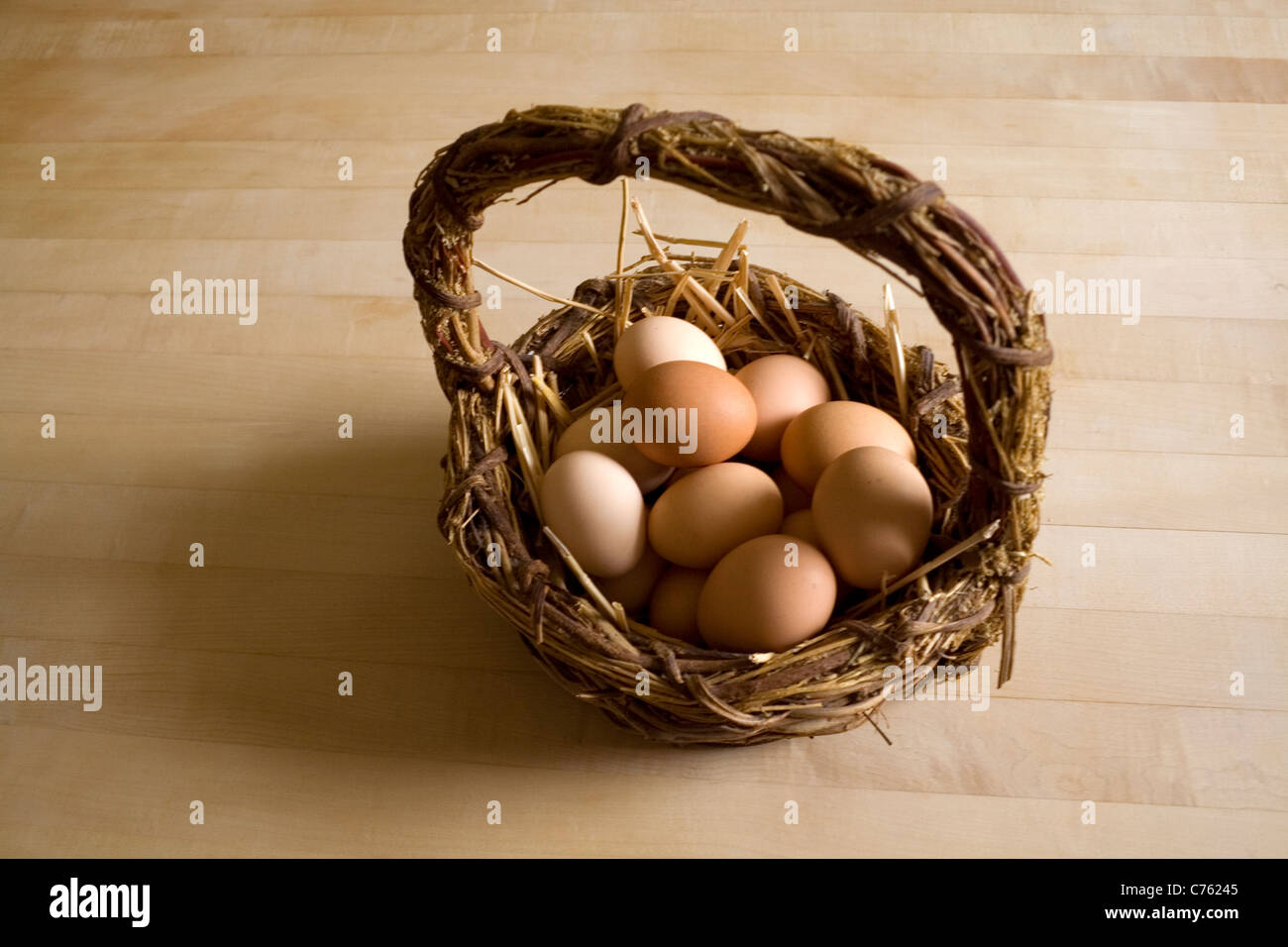 A basket of free range eggs on a bed of straw Stock Photo