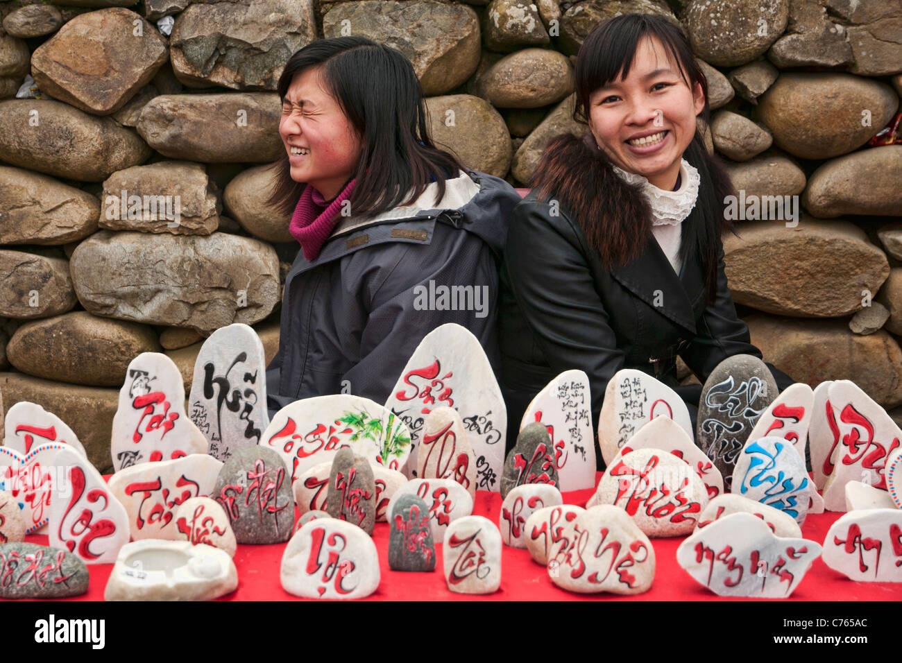 Vietnamese girls selling painted stones at the Dragon festival near Lao Cai in Vietnam Stock Photo