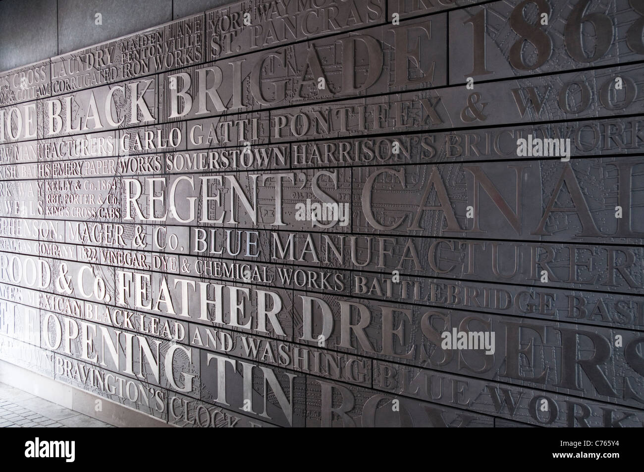 A wall of words and names relating to the history of the Kings Cross area, at Regent Quarter, a complex on York Way, London. Stock Photo
