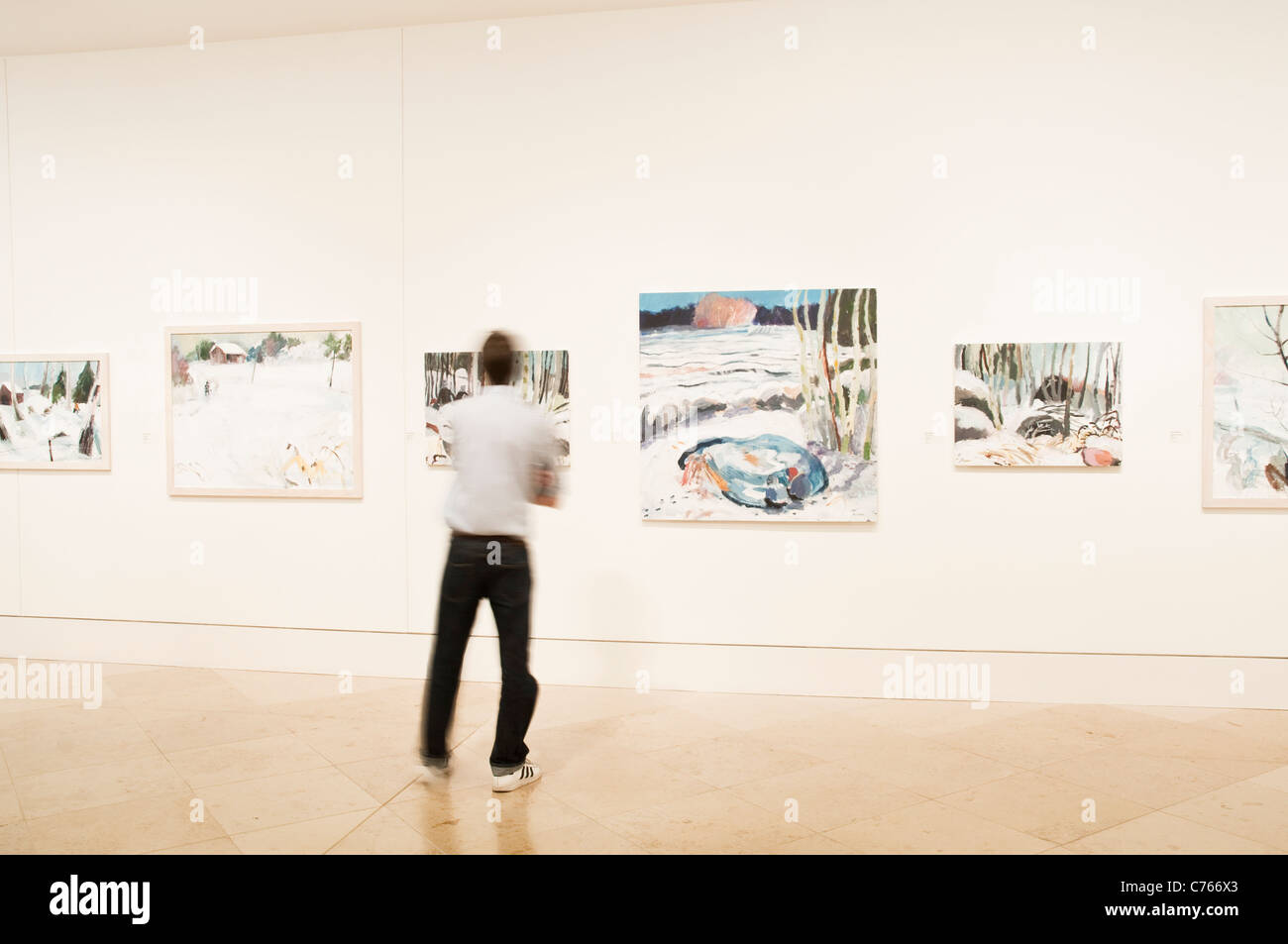 Man at an exhibition in Kings Place Gallery, by Swedish artist Brita Granström, at the Kings Place complex in London. Stock Photo