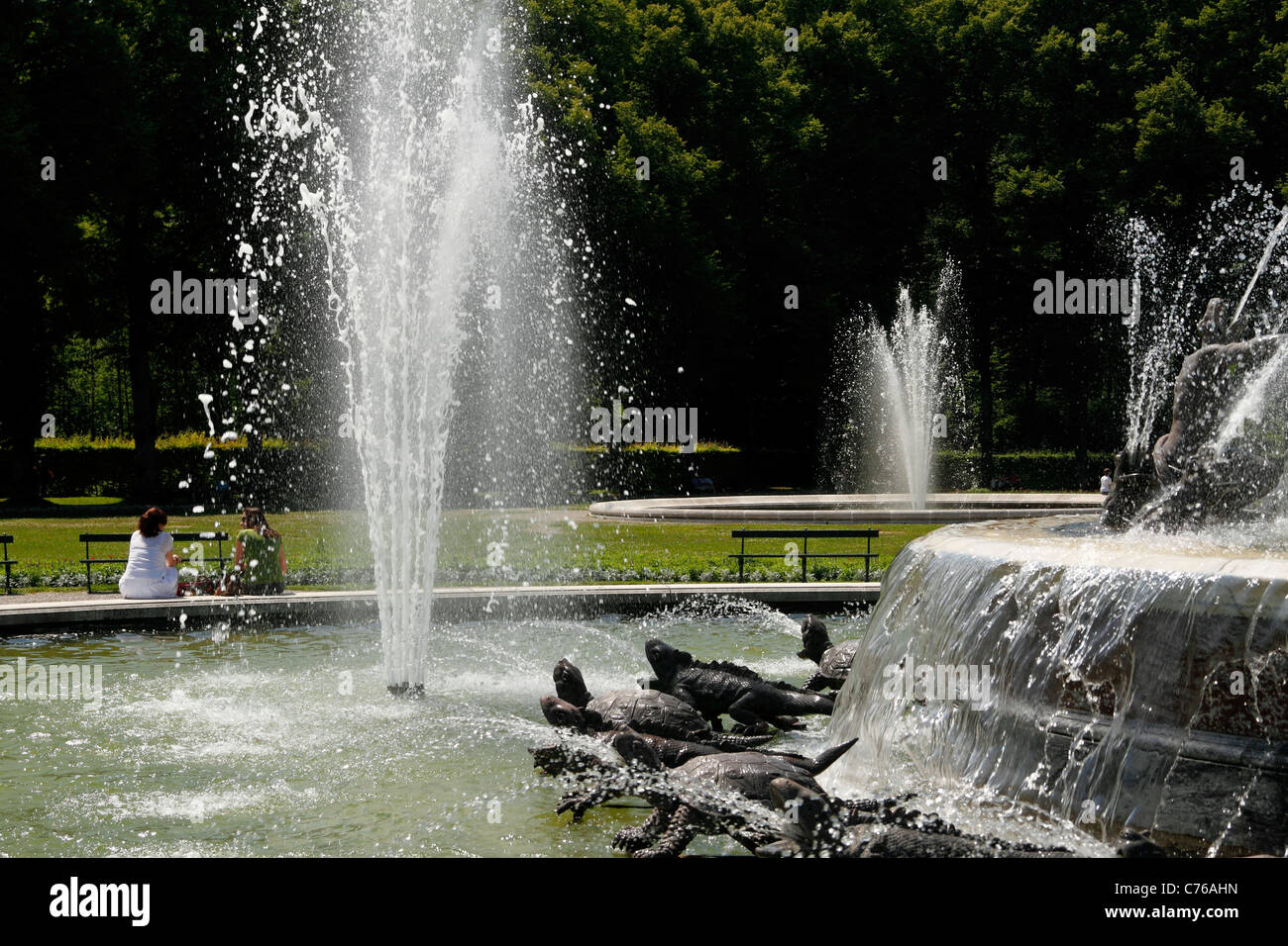 People sitting at the Latona Fountain, Herrenchiemsee Herreninsel Upper Bavaria Germany Stock Photo
