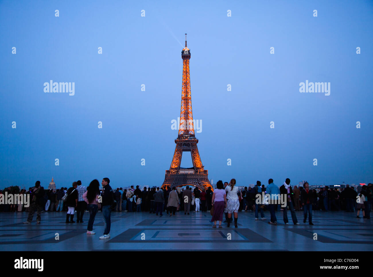 France, Paris, Tourists looking at Eiffel Tower illuminated at dusk Stock Photo