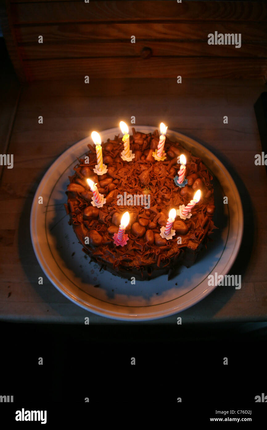 chocolate birthday cake with eight lit candles Stock Photo - Alamy