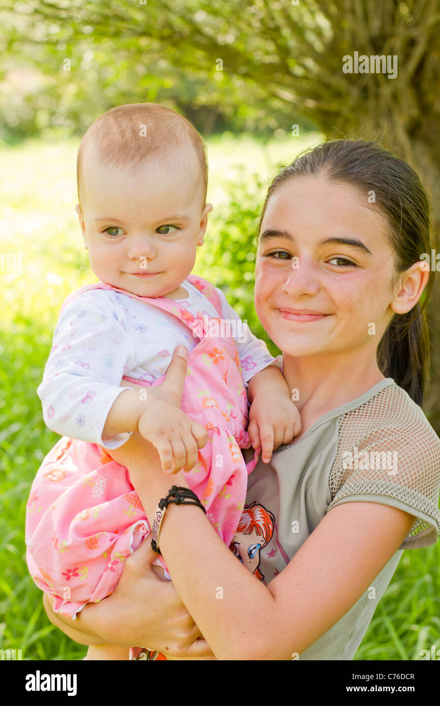 A teenage girl with a baby in arms Stock Photo
