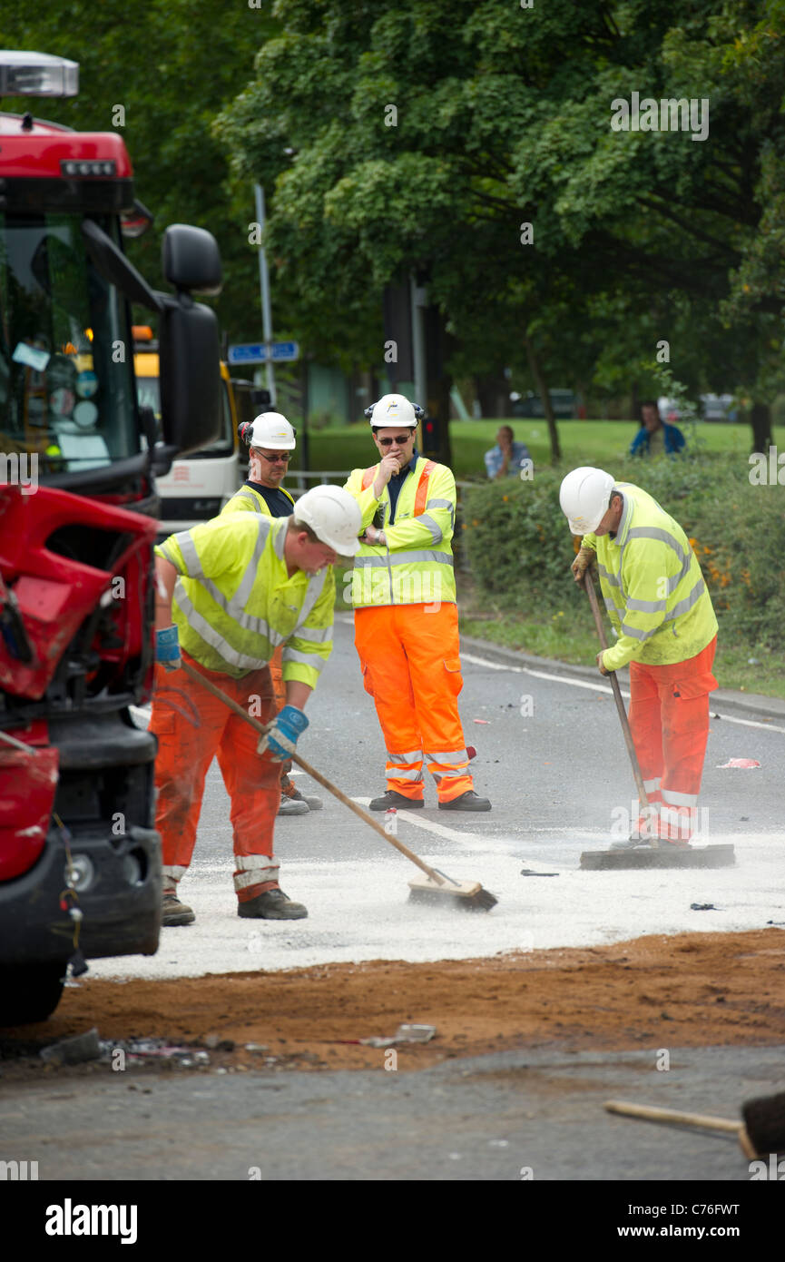 Highways Agency workers clearing the road at the scene of serious road accident between a fire engine and a car. Stock Photo