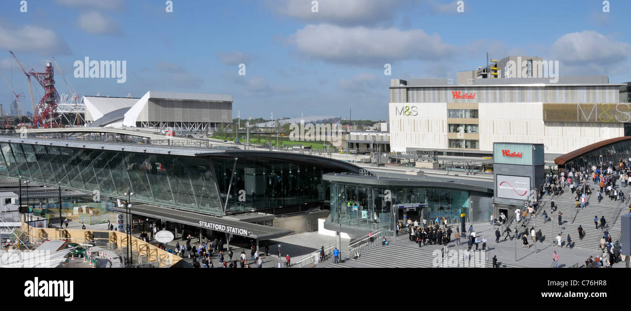 Aerial urban view 2012 Olympic Park beyond crowds of people at busy Stratford train station & Westfield shopping Centre Newham East London England UK Stock Photo