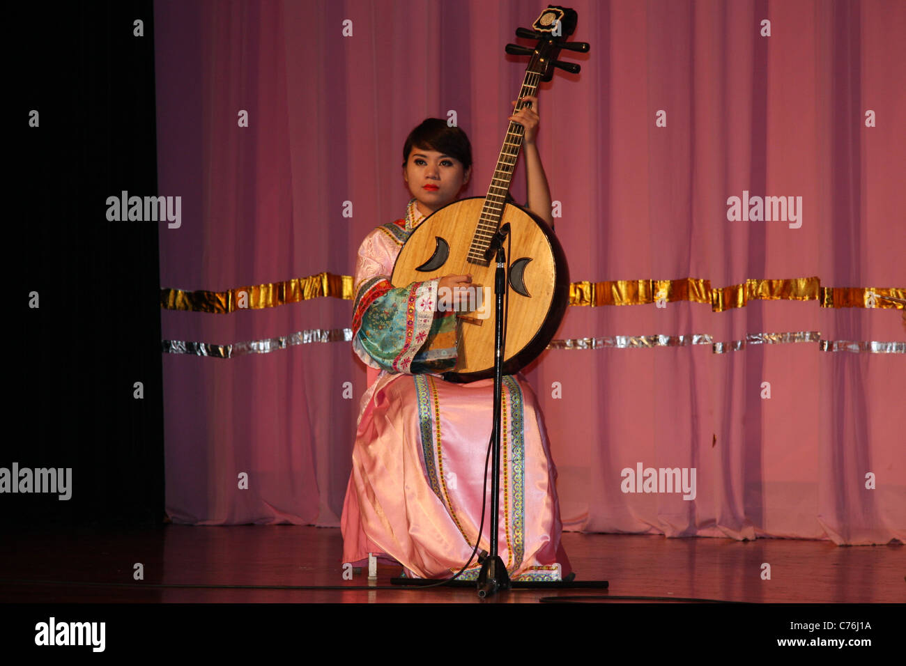 Female musician playing a traditional stringed instrument at Tang ...