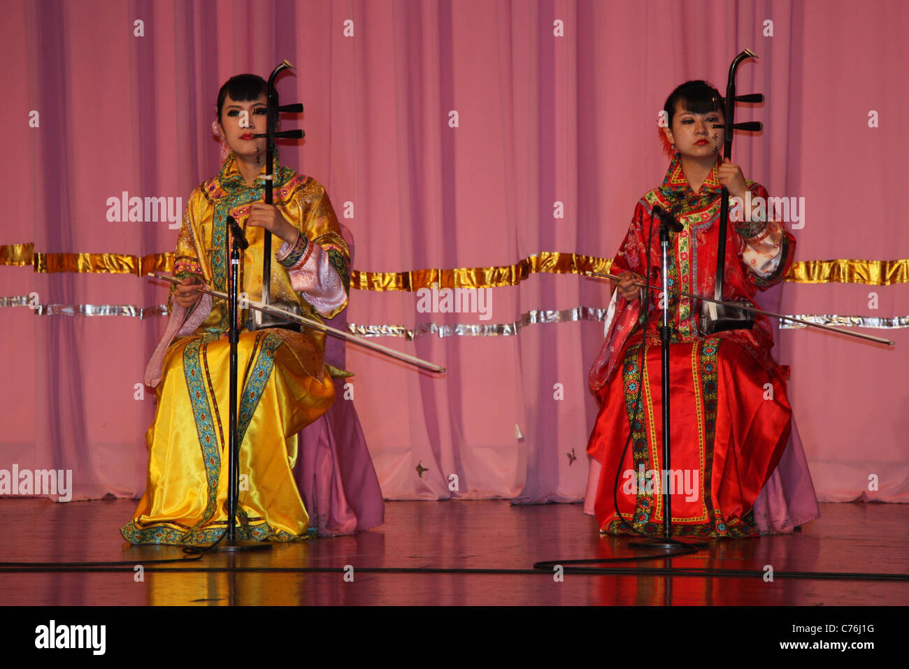 Two female musicians playing traditional stringed instruments at Tang