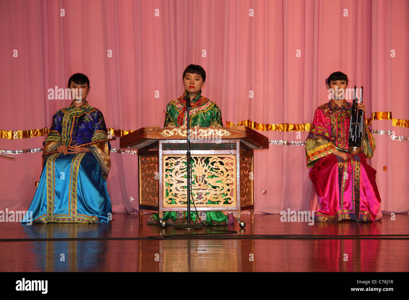 Three female musicians playing traditional stringed and wind instruments at Tang dynasty dinner