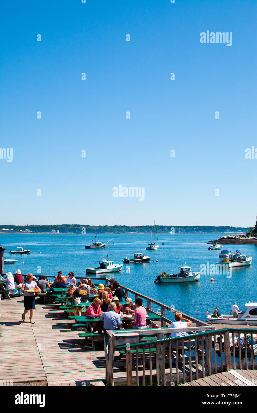 Crowds sit at picnic tables and enjoy the views of the harbor below. Stock Photo