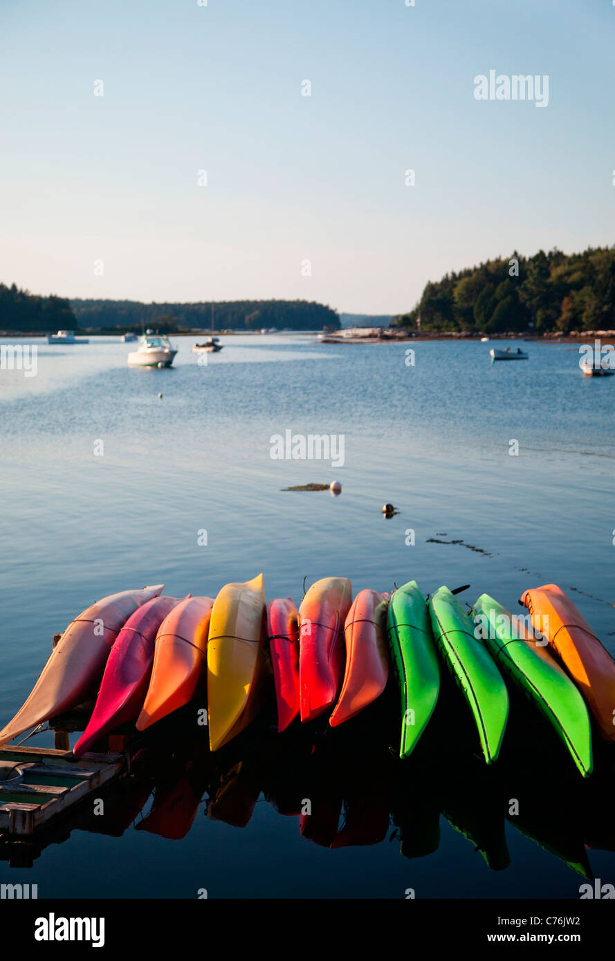 A line of colorful canoes in a small harbor at dusk. Stock Photo