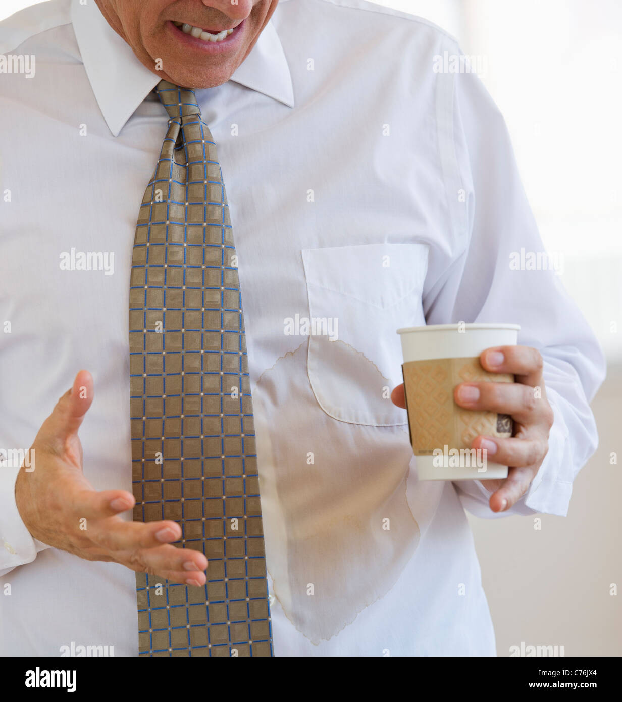 Businessman spilling coffee on shirt Stock Photo - Alamy