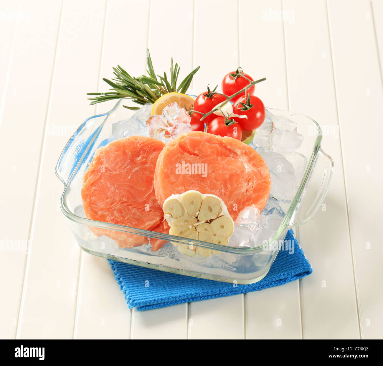 Raw salmon patties and other ingredients on ice Stock Photo