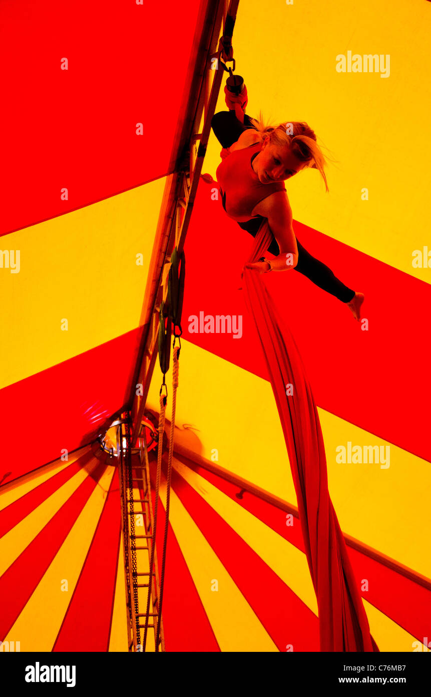 a girl hanging from a trapeze in a circus tent at Shambala Festival 2011 Stock Photo