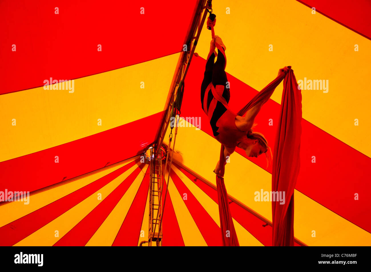 Girl hanging off a trapeze from the top of a circus tent at Shambala Festival 2011 Stock Photo