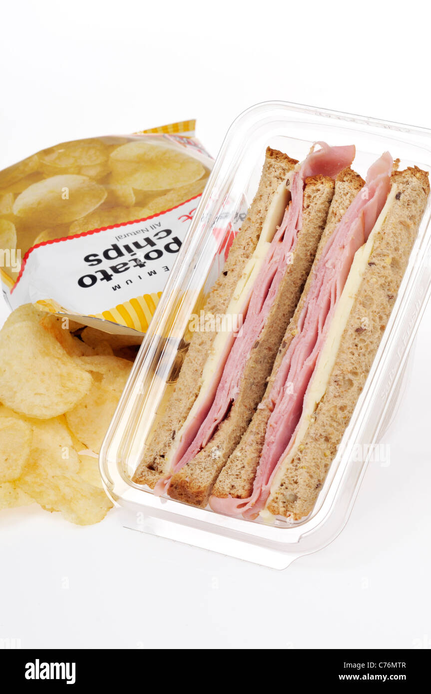 Prepared ham and cheese take away sandwich in plastic pack with bag of crisps on white background. Stock Photo