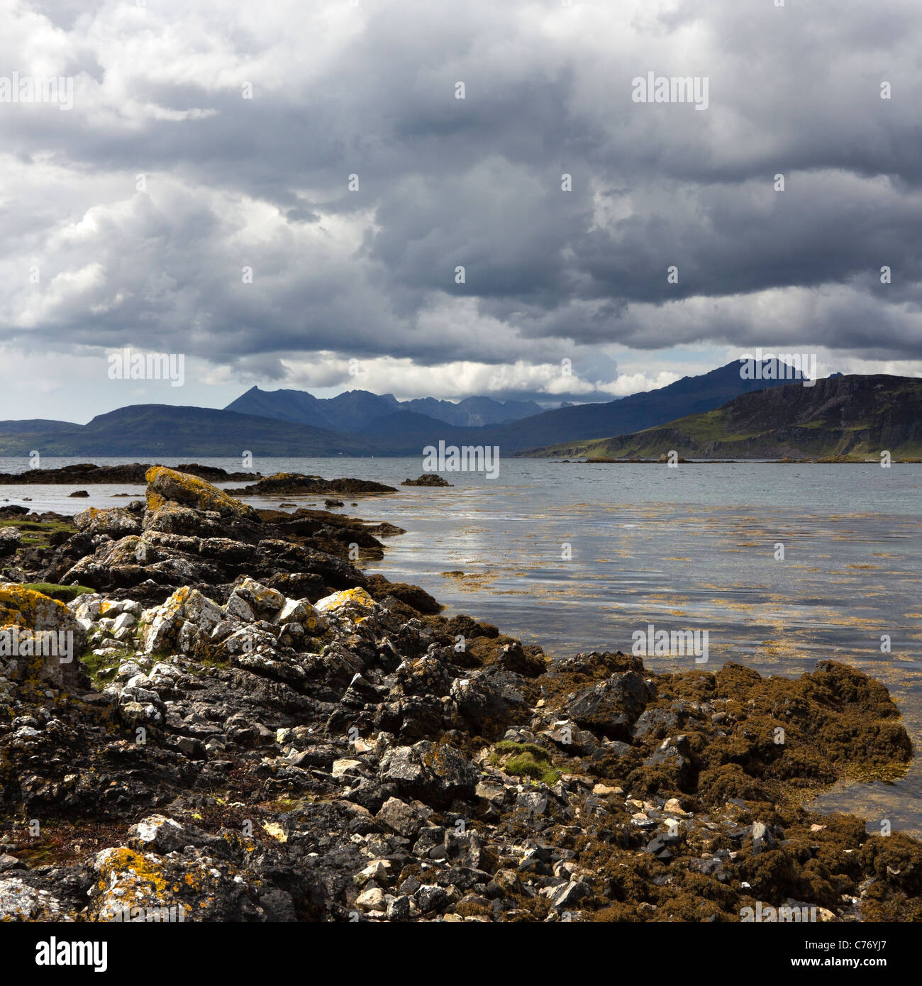 Rocky shoreline of Loch Eishort with Black Cuillin Mountains beyond, Ord, Isle of Skye, Scotland, UK Stock Photo