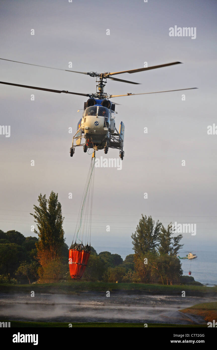 Kamov Ka-32A11BC helicopter collecting water, Cabopino Golf, Costa del Sol, Malaga Province, Andalucia, Spain, Western Europe. Stock Photo