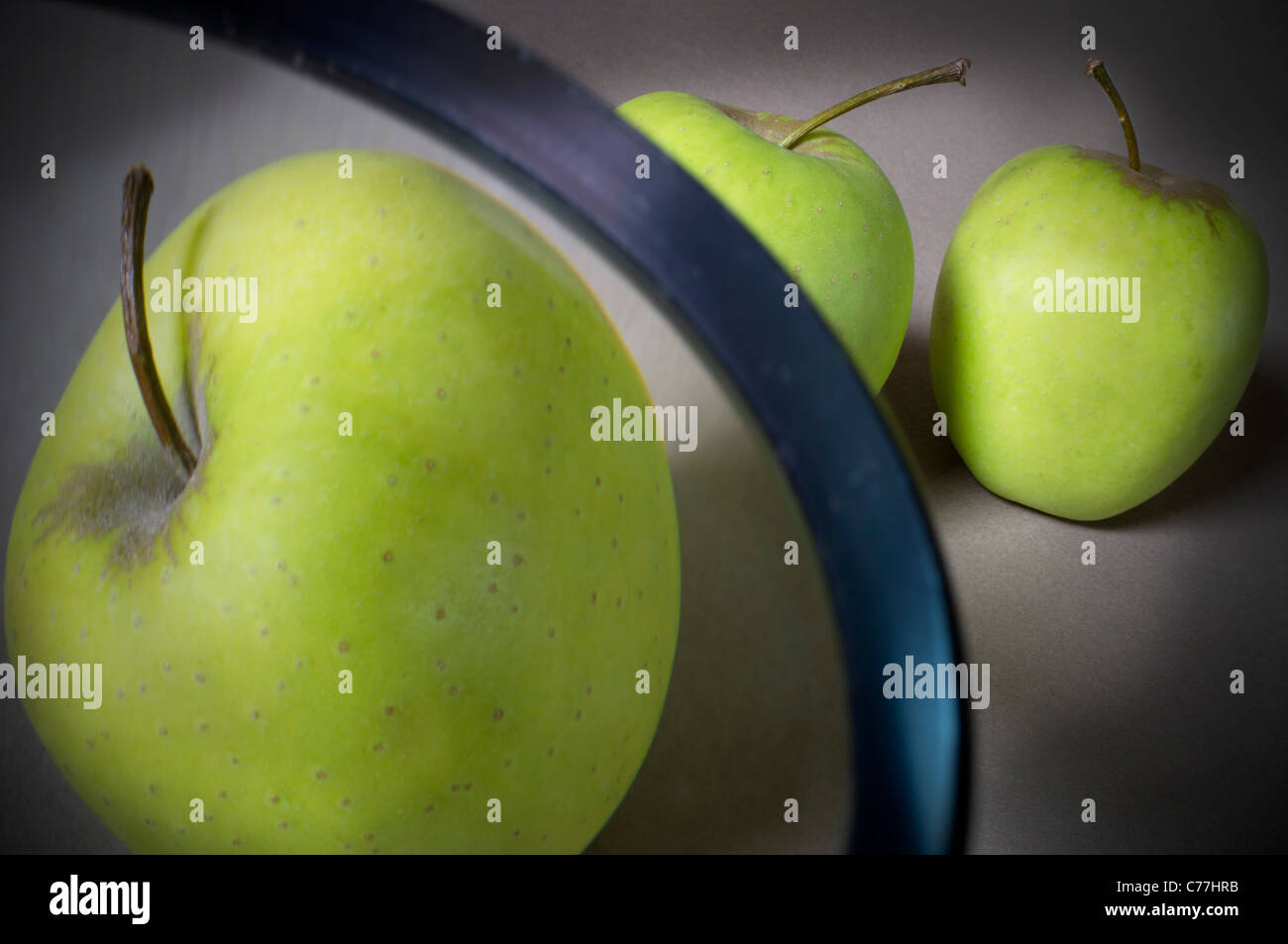 One of three apples under a magnifying glass Stock Photo Alamy