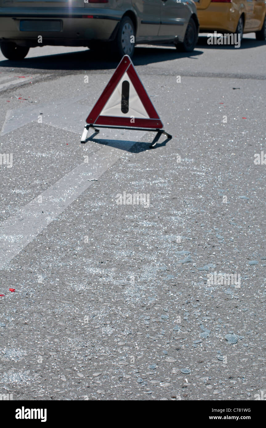 Broken glass from car on a road. Road sign attention Stock Photo