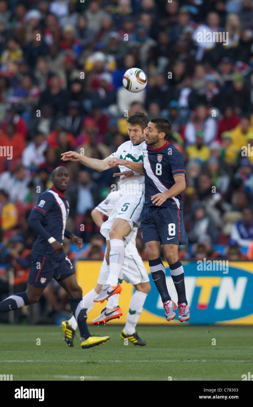 Bostjan Cesar of Slovenia (5) and Clint Dempsey of the United States (8) jump for a header during a 2010 World Cup soccer match. Stock Photo