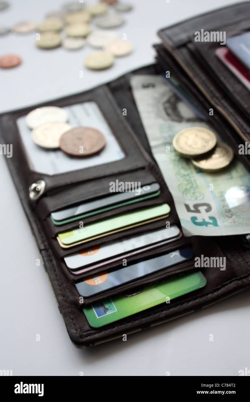 A leather purse containing money and credit cards Stock Photo