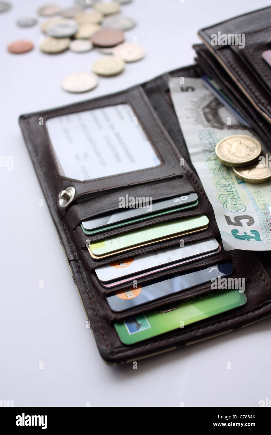 A leather purse containing money and credit cards Stock Photo