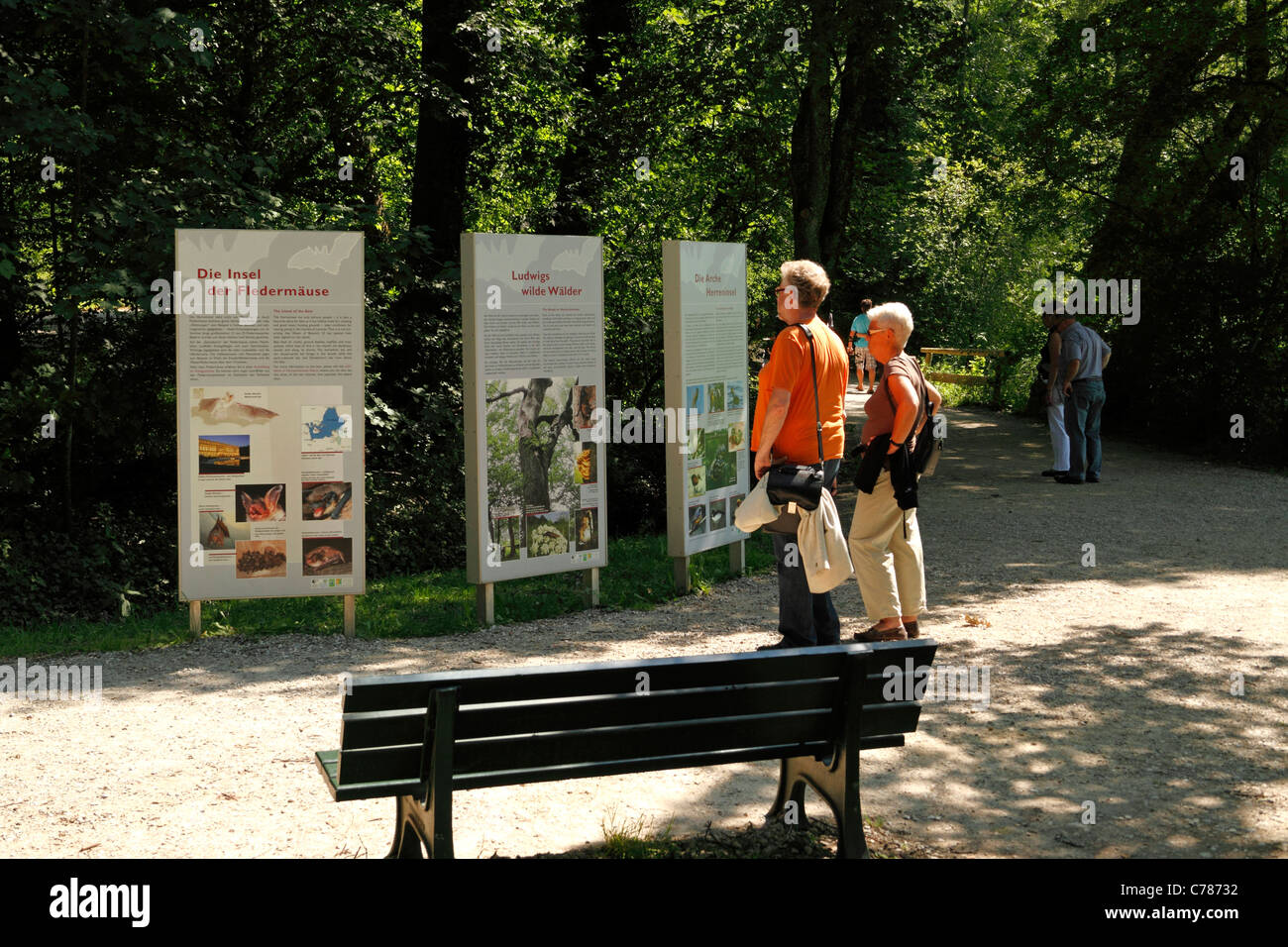 Tourists study a information board on the Herrenchiemsee Herreninsel Upper Bavaria Germany Stock Photo
