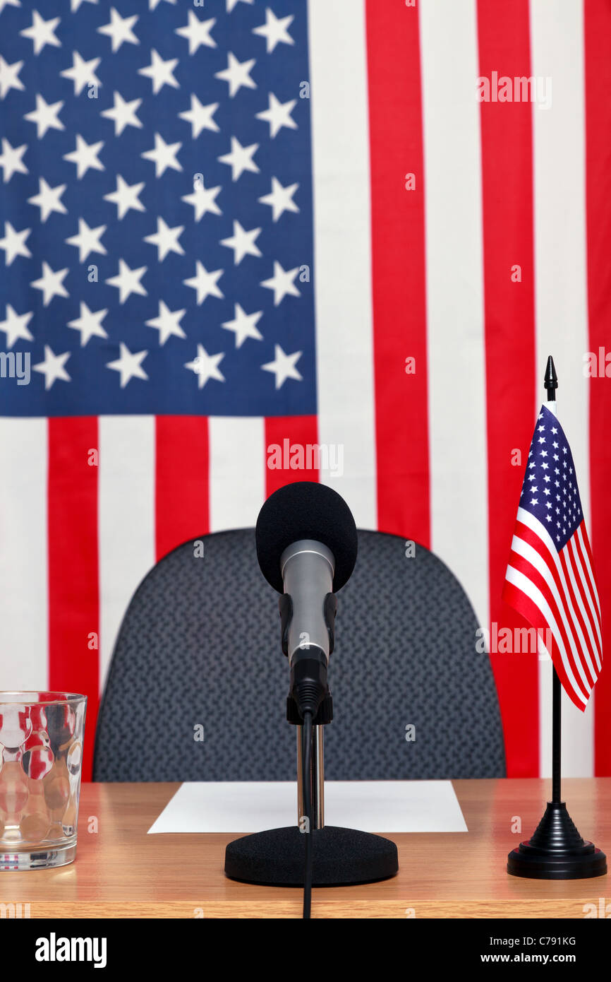 Photo of an American themed conference desk with microphone and flags. Stock Photo