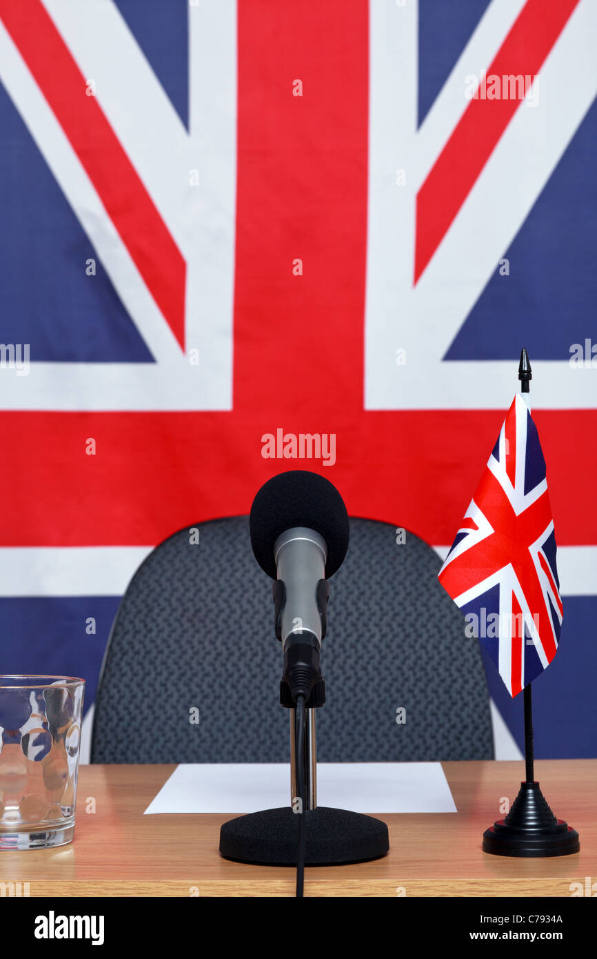 Photo of a United Kingdom themed conference desk with microphone and flags. Stock Photo