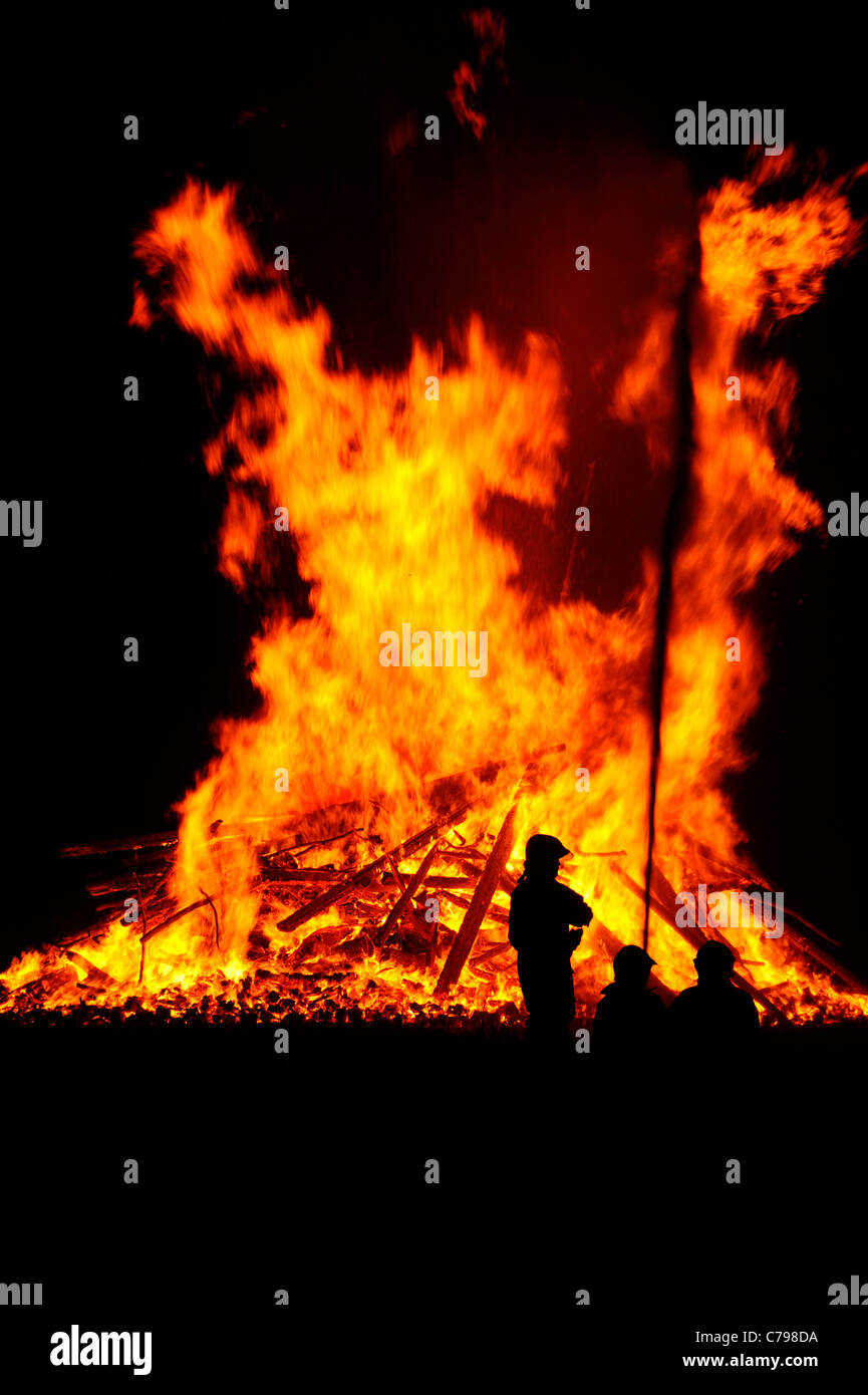 Two firemen silhouetted against a huge blaze Stock Photo