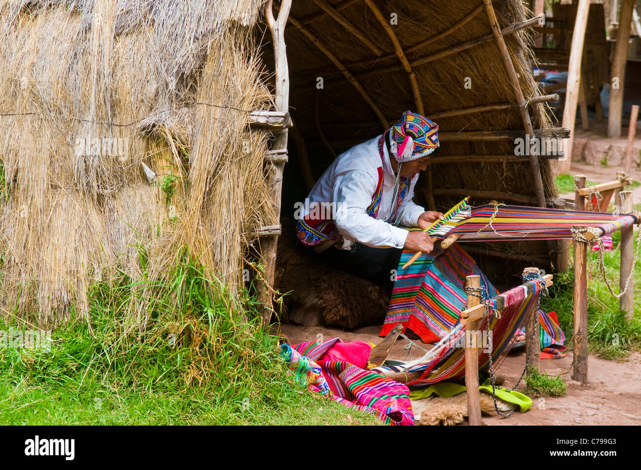 Quechua Indian man weaving with strap loom Stock Photo