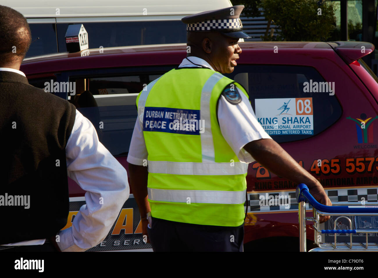Police officer and taxi at King Shaka International Airport. Durban, KwaZulu-Natal, South Africa. Stock Photo