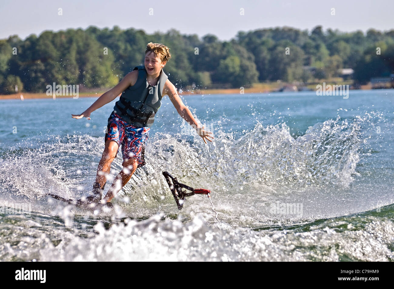 A young boy let go of the rope as he falls into the water Stock Photo