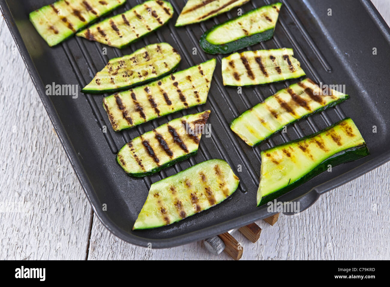 grilled zucchini in a grill pan on a coaster Stock Photo