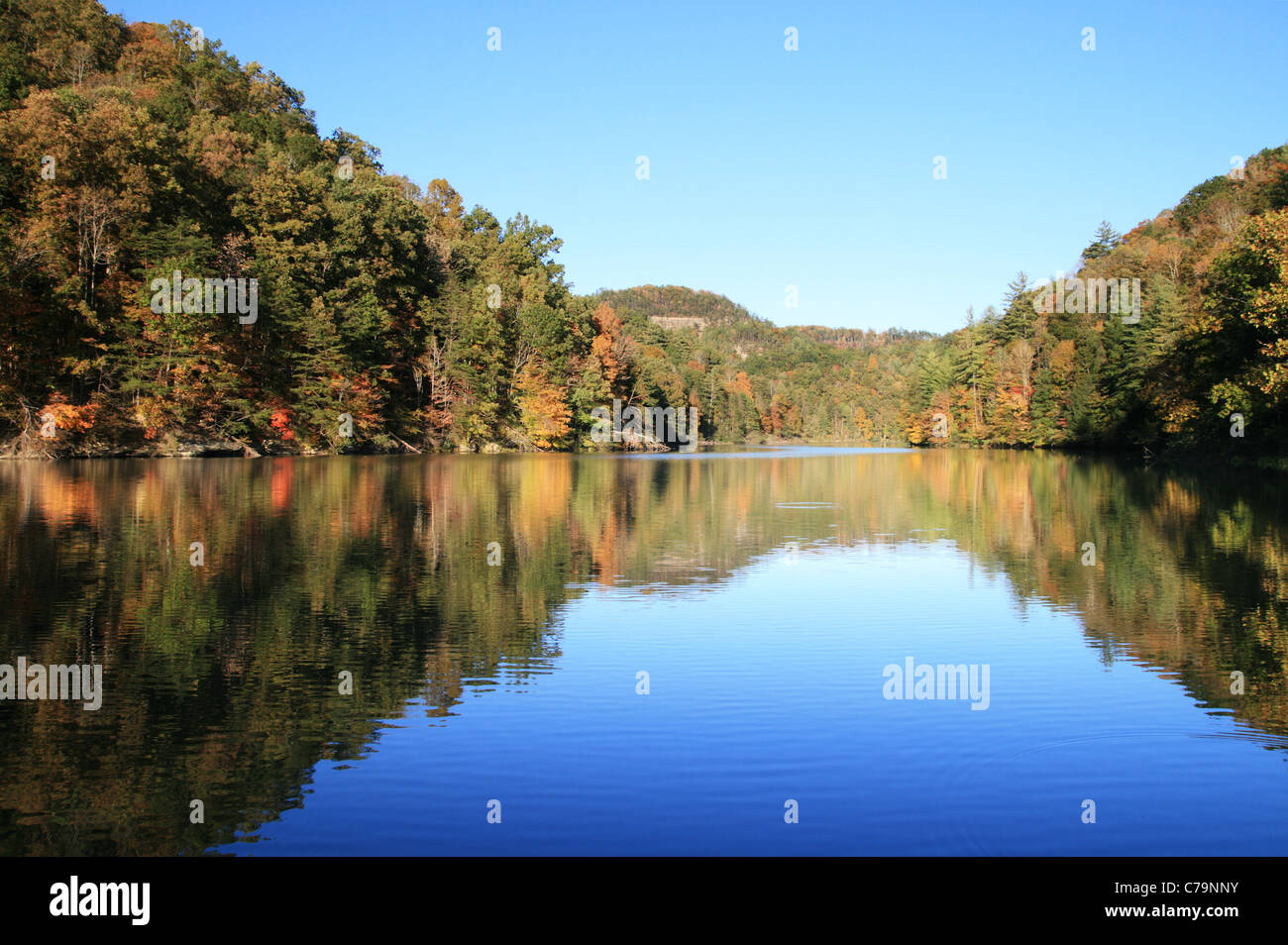early fall reflection in Mill Creek Lake, Natural Bridge State Park, Kentucky with the leaves just starting to change color Stock Photo