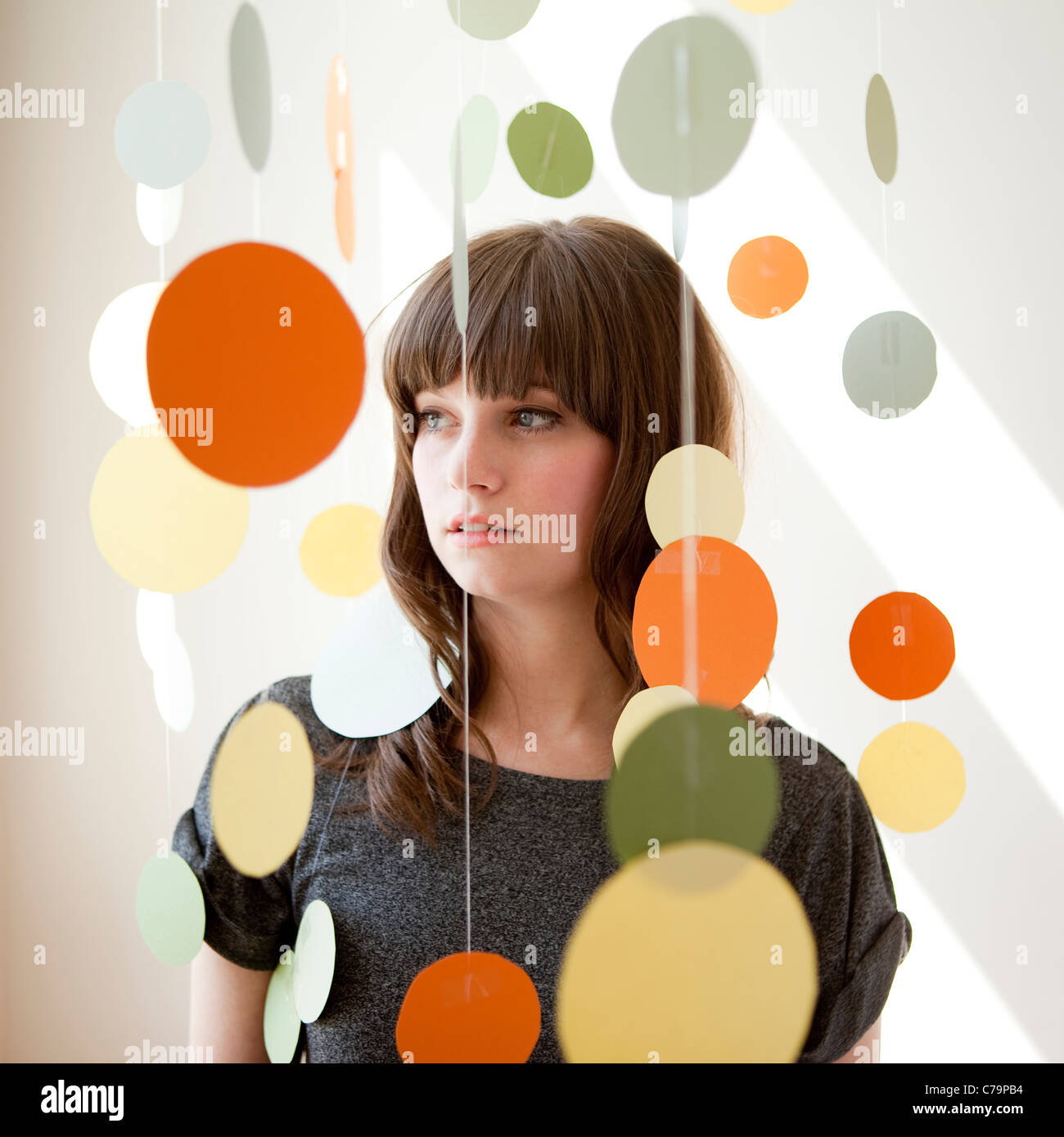 Portrait of young woman under hanging decoration Stock Photo