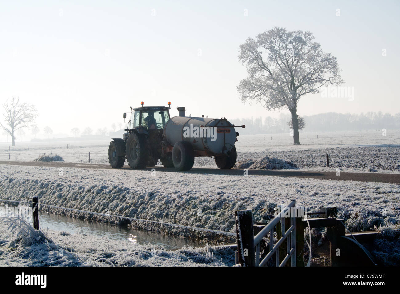 Farmer driving on a small path in the Dutch polder Stock Photo