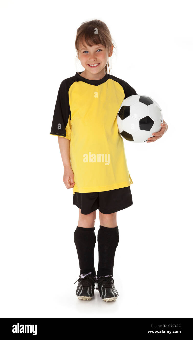 Full length view of seven year old girl holding soccer ball on white
