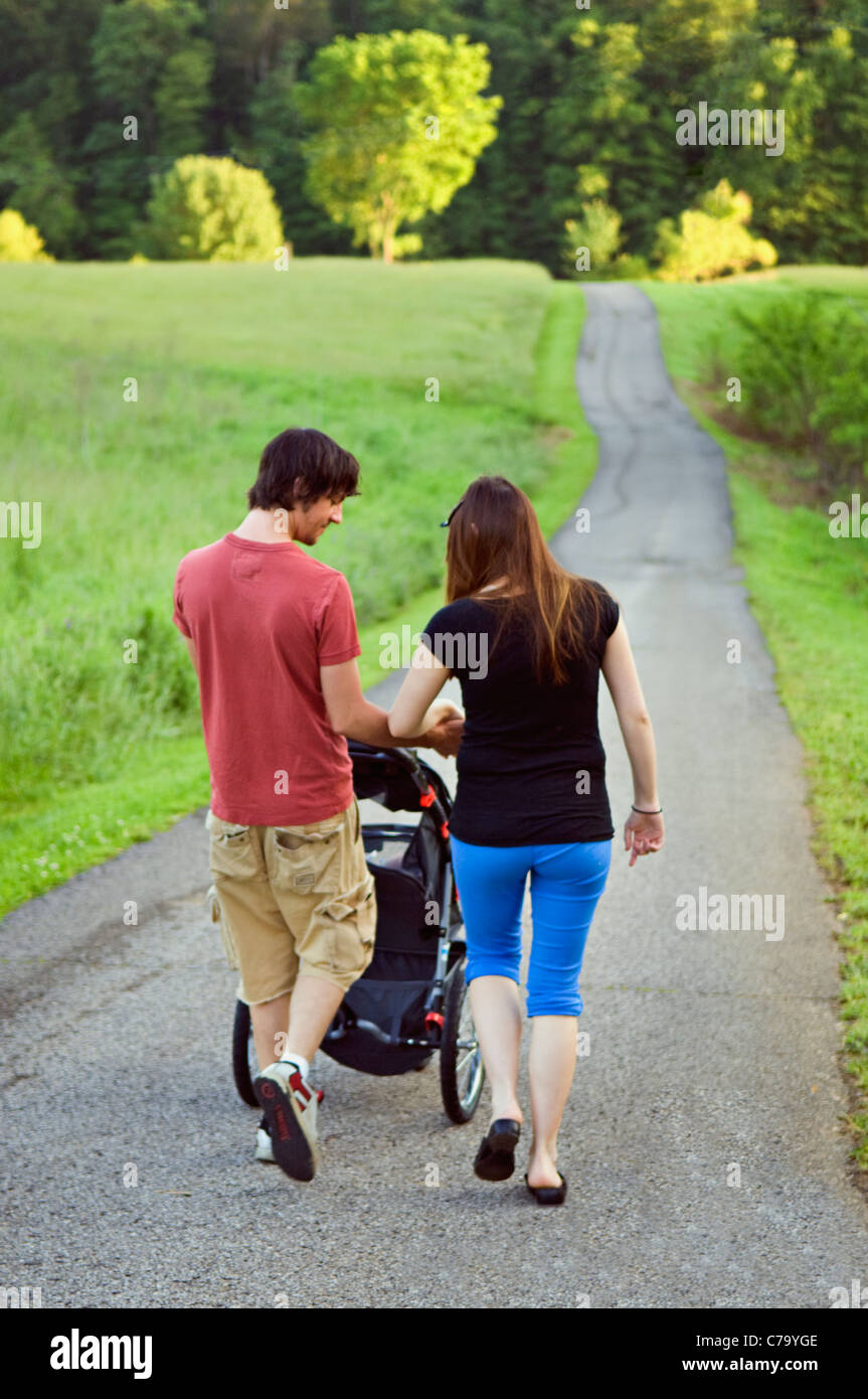 Young Couple Strolling their New Baby down Country Lane in Floyd County, Indiana Stock Photo