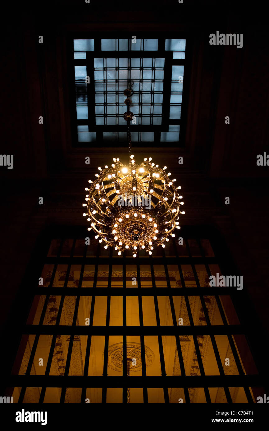A large hanging chandelier inside the New York Grand Central Terminal train station. Stock Photo