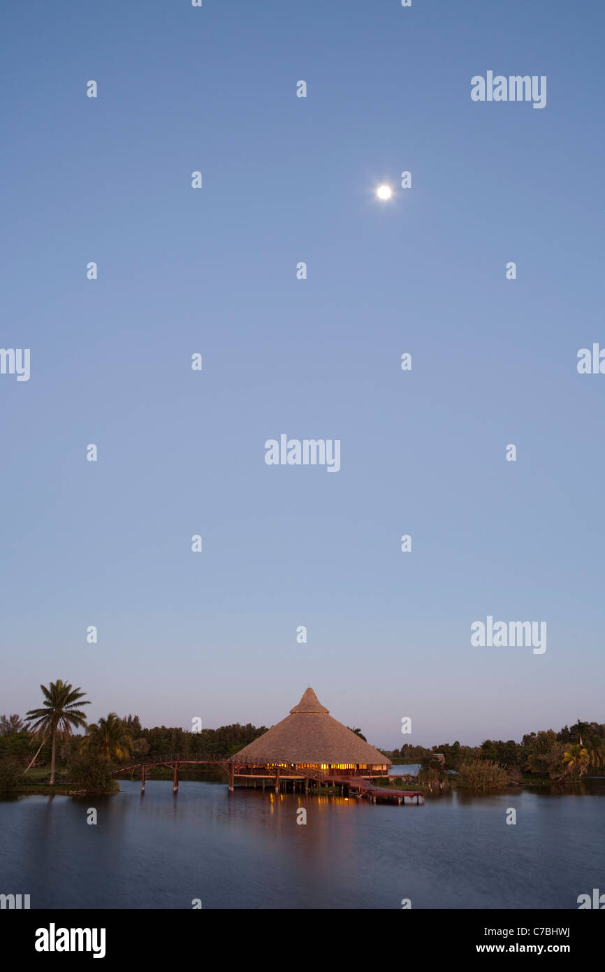 Moon above restaurant at Villa Guama hotel on the shores of Laguna del Tesoro (Treasure Lake) at dusk, Guama, Matanzas, Cuba Stock Photo