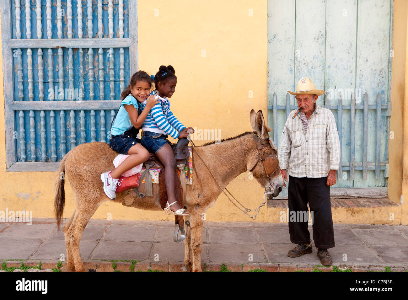 Photo opportunity, Happy children sitting on a donkey, Trinidad, Sancti Spiritus, Cuba, Caribbean Stock Photo