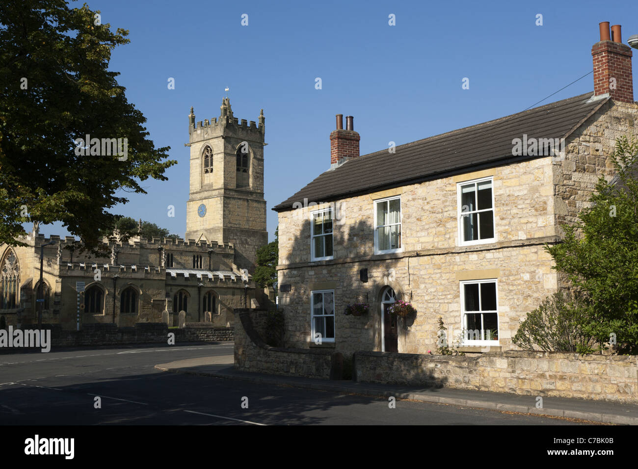 400 year old limestone farmhouse with St Peter's Church in the background, Barnburgh, Yorkshire, England. Stock Photo