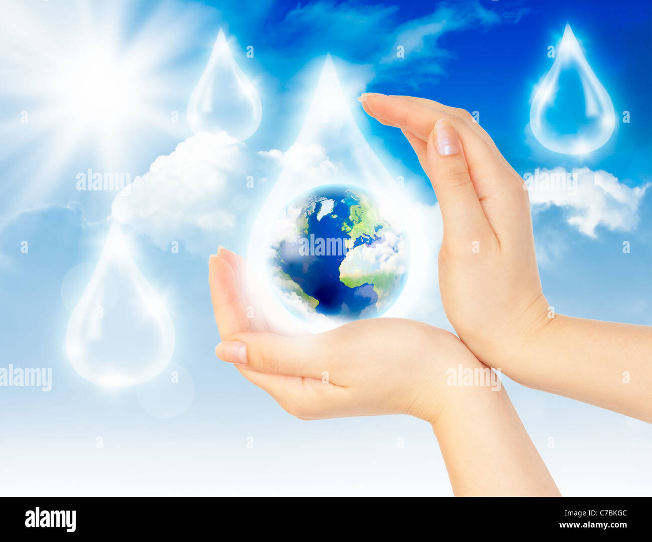 Drop of water with Earth inside and hands on sky background. The symbol of Save Planet. Stock Photo