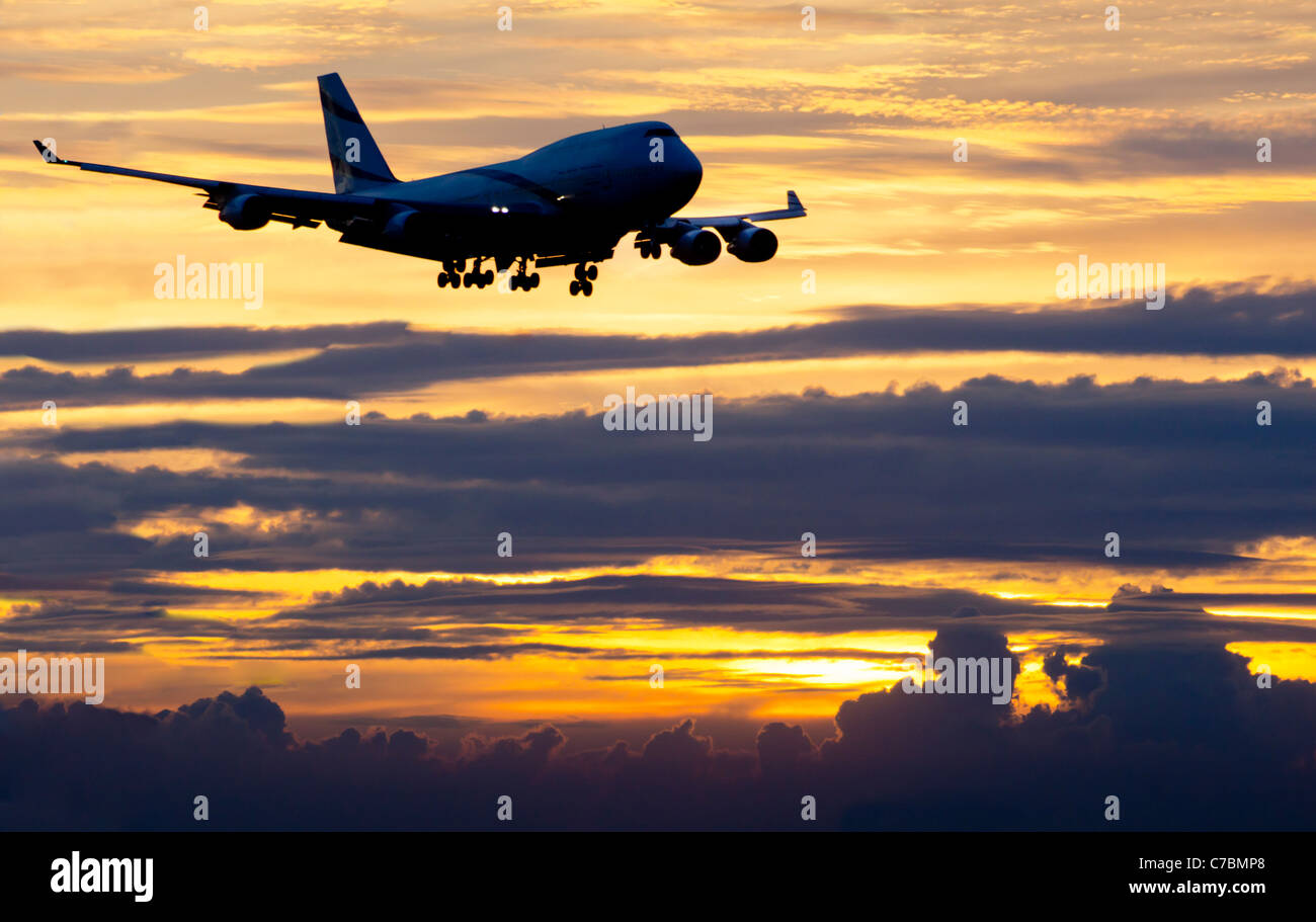 Jumbo jet approaching airport at sunset Stock Photo Alamy